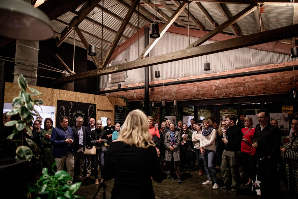 A large group of people listening to a speaker at a Hamlet event. The event is to celebrate 5 years of Hamlet.